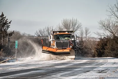 A snowplow clears a snowy road in Wabasha, MN during winter.