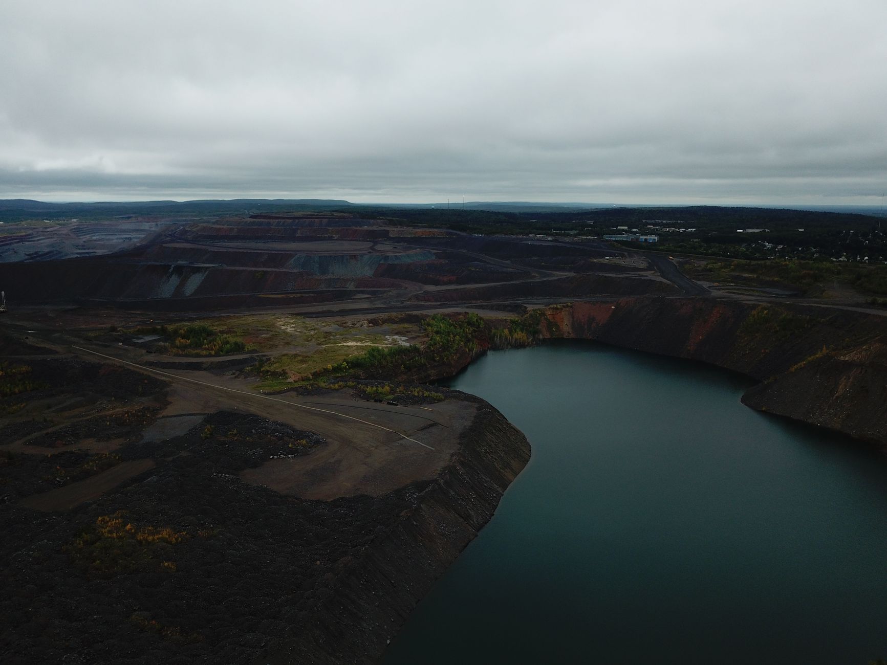 Aerial view of mine lake and surrounding landscape in Eveleth, Minnesota, on an overcast day.